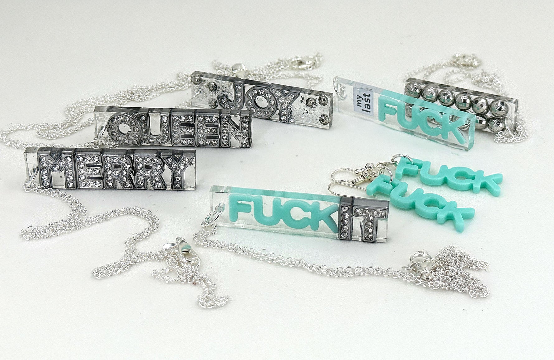 Necklaces with various text designs on a white background